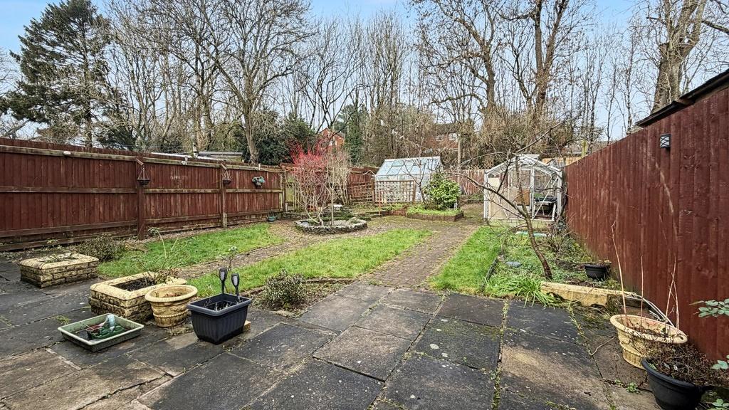 Private rear garden with paved patio, planted b...