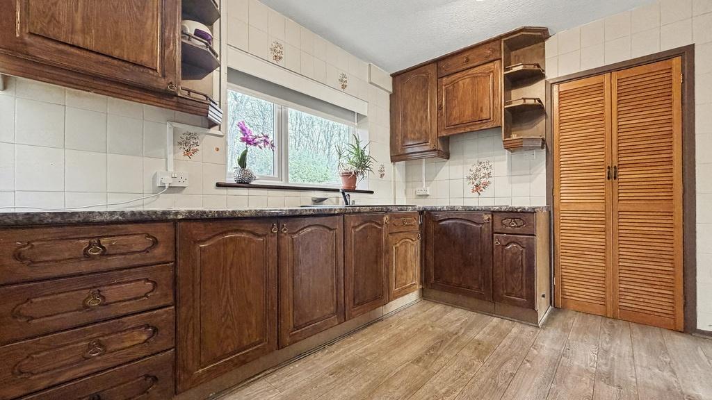 Bright traditional-style kitchen with warm wood...