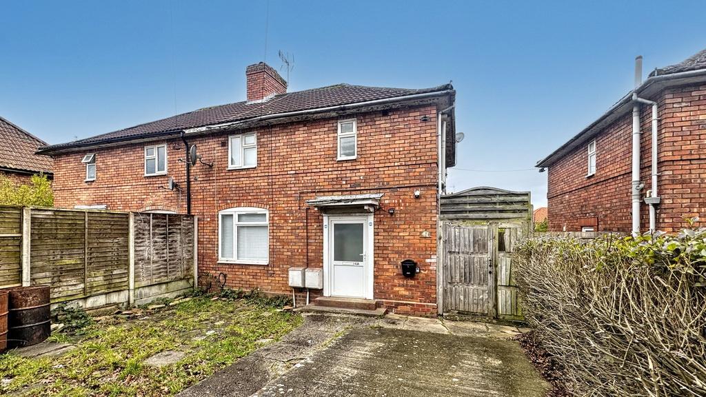 Brick semi-detached house with a paved driveway...