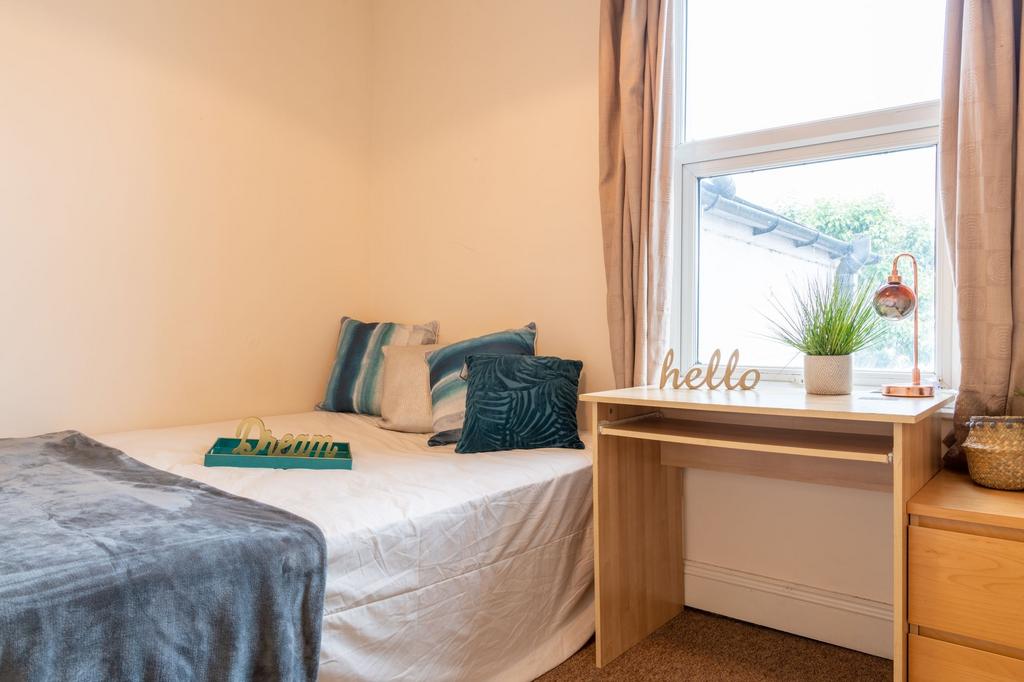 Bright, neatly styled single bedroom with a com...