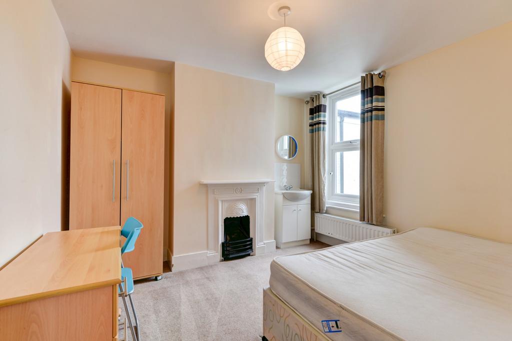 A spacious and well-lit bedroom with a comforta...