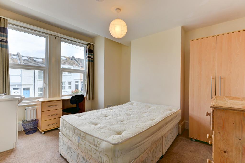 Bright, simply furnished bedroom with a large w...
