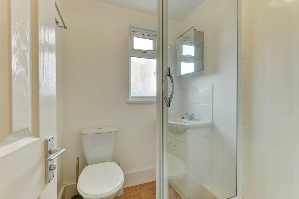 Compact, modern bathroom with a corner glass sh...