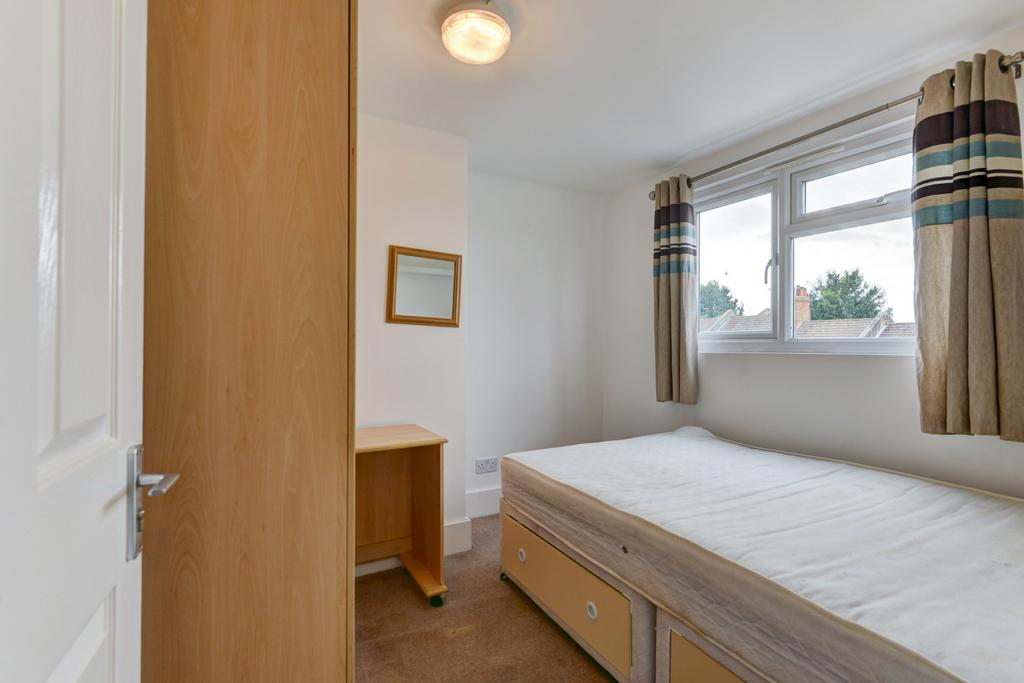 Bright, simply furnished bedroom with a large w...