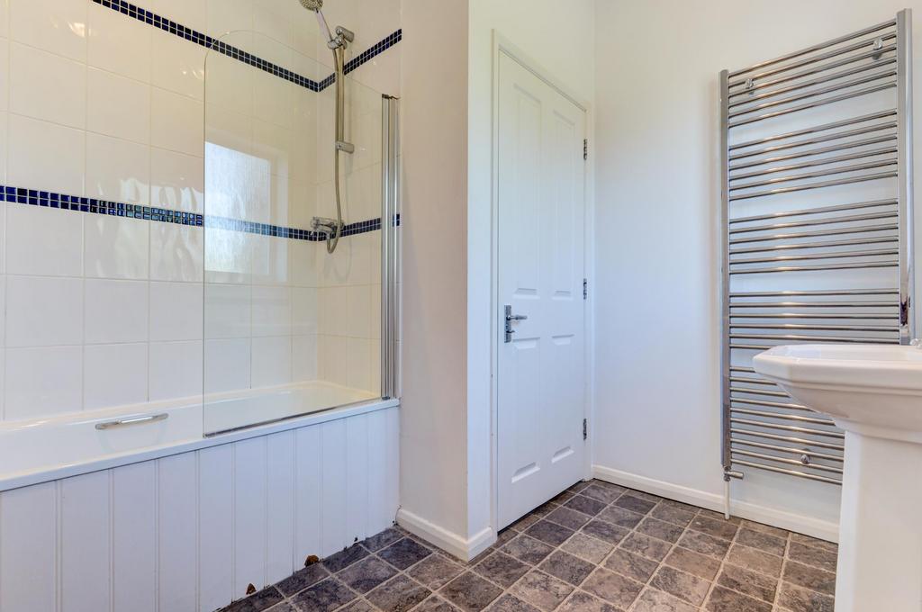 Bright, modern bathroom with a combined bath an...