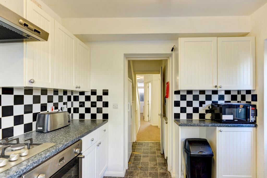 A compact, well-maintained kitchen featuring bl...