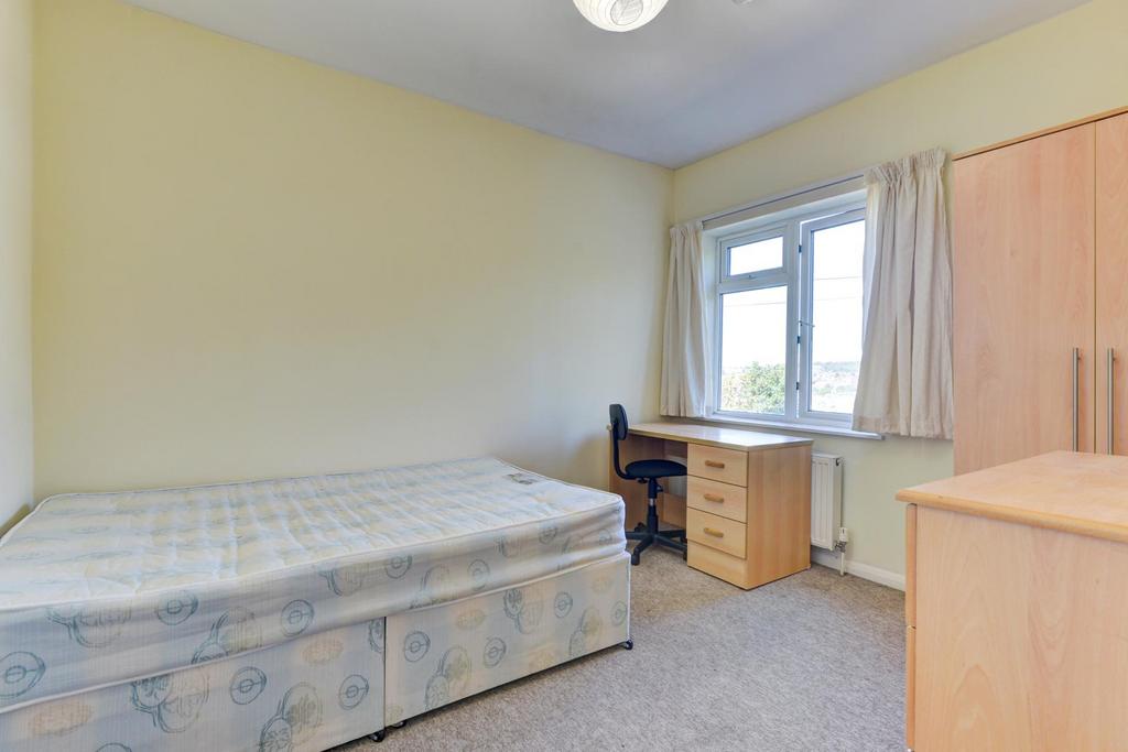 A well-lit, tidy single bedroom with a comforta...