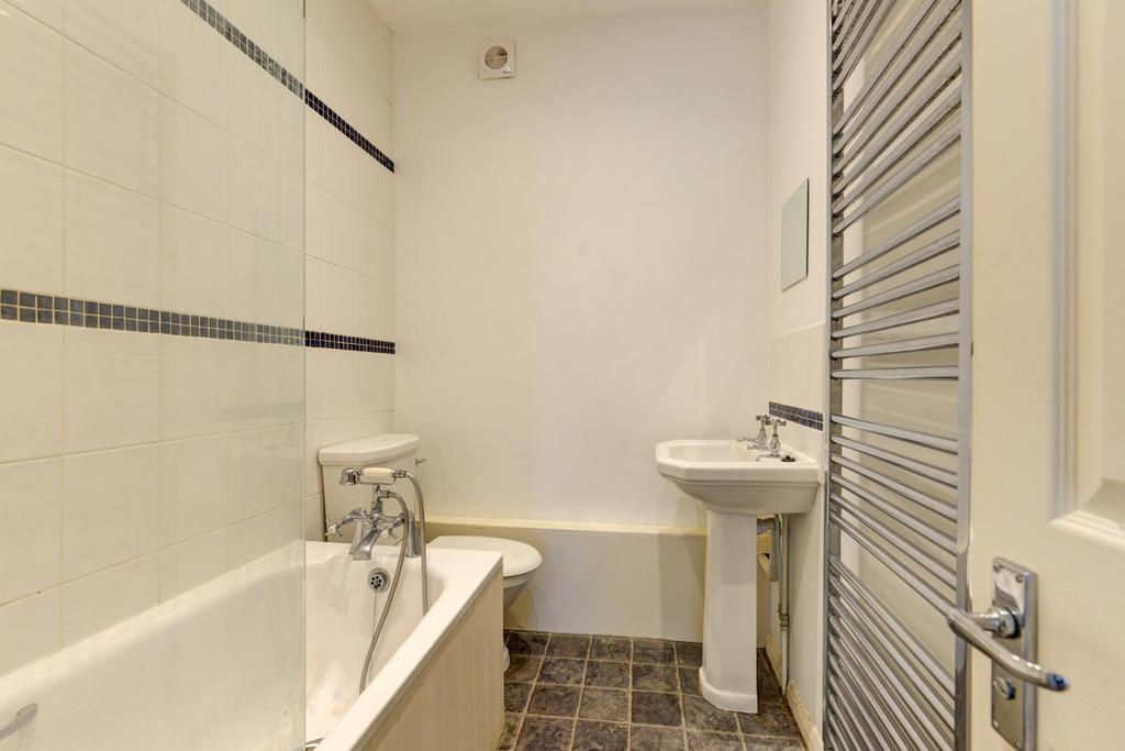 Bright, well-maintained bathroom with a bathtub...