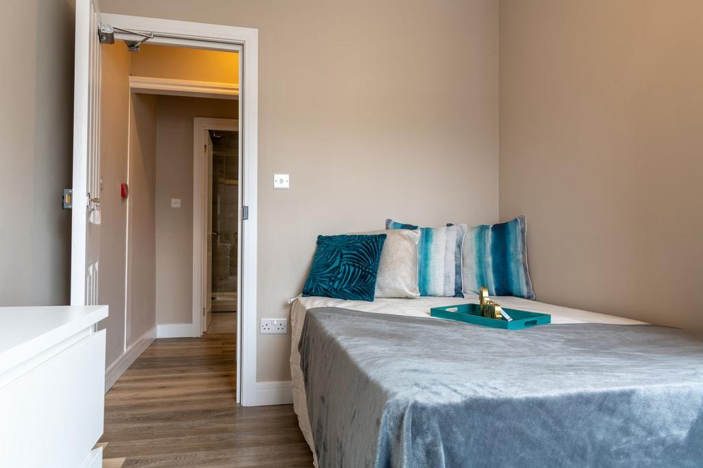Bright, neatly staged double bedroom with a com...