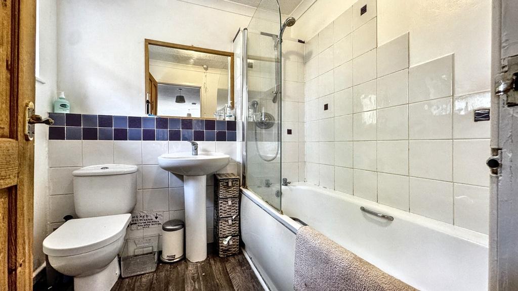 Bright, modern bathroom with a combined bath an...