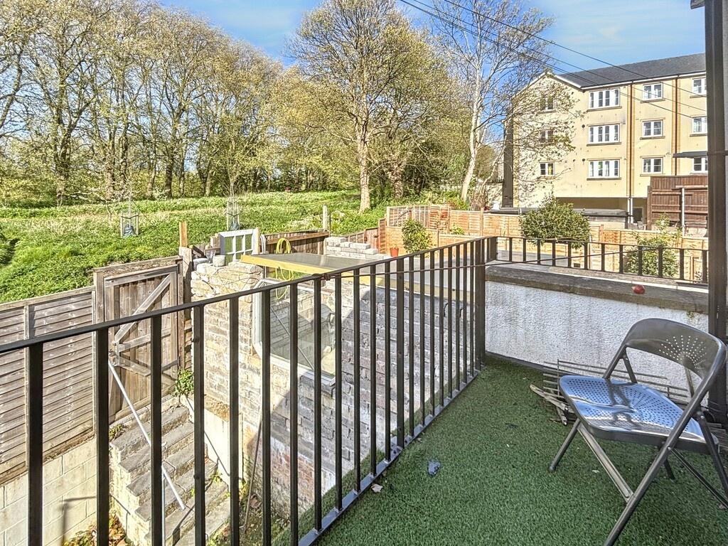 Sunny first-floor balcony with seating overlook...