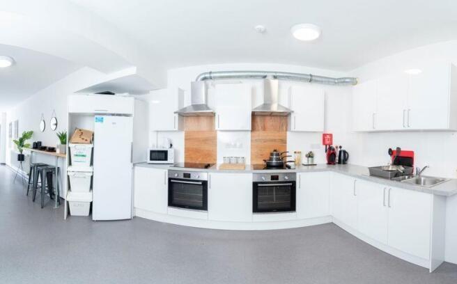 Bright, modern communal kitchen with twin ovens...