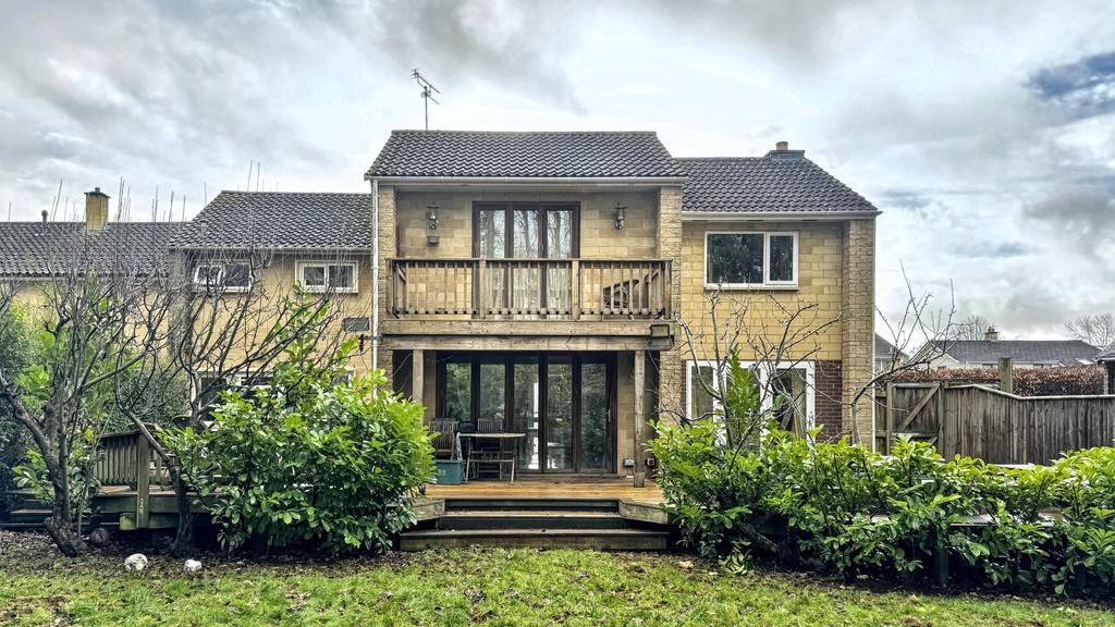 Rear garden with a paved patio and raised decki...
