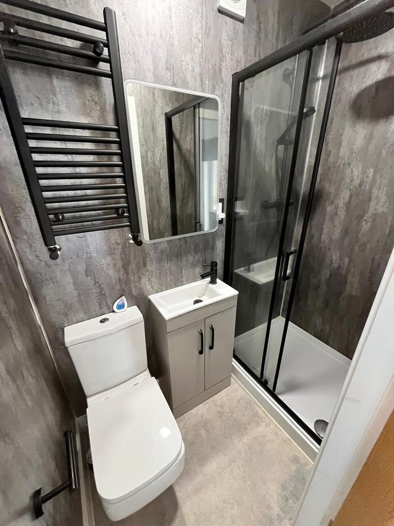 Contemporary ensuite-style bathroom with a glas...