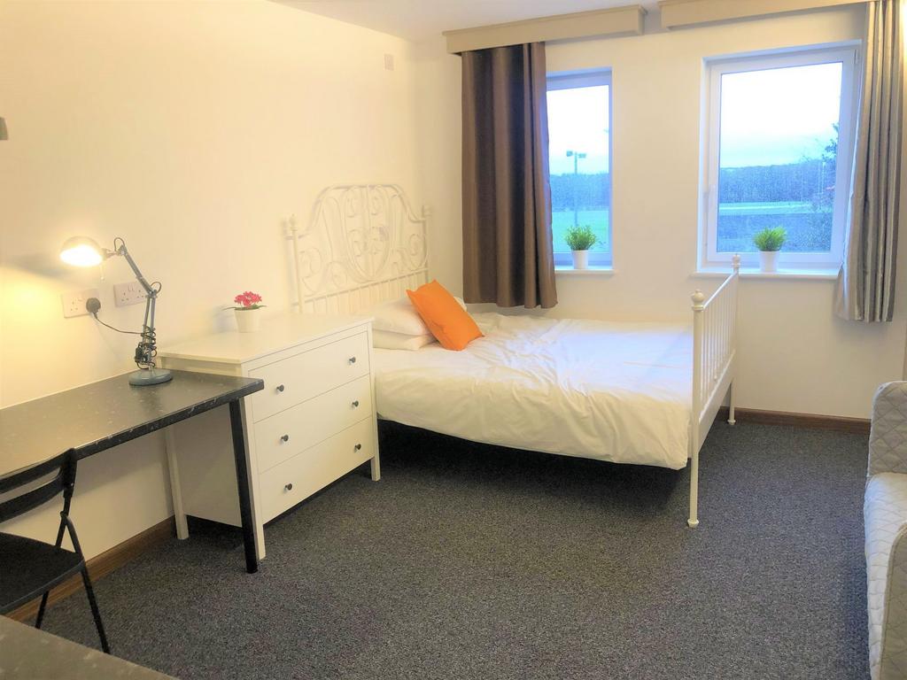 Bright and tidy single bedroom featuring a cozy...
