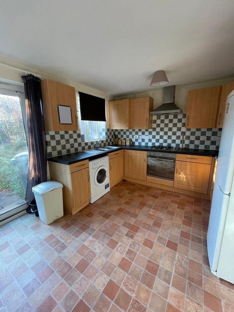 Bright fitted kitchen with wood-effect cabinets...