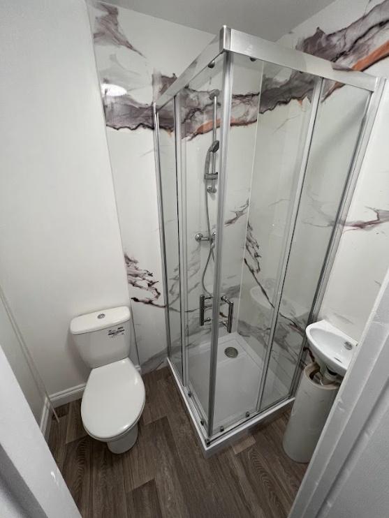 Bright, modern bathroom with a glass-enclosed c...