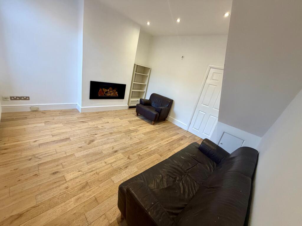 Bright, modern living space with warm wood floo...