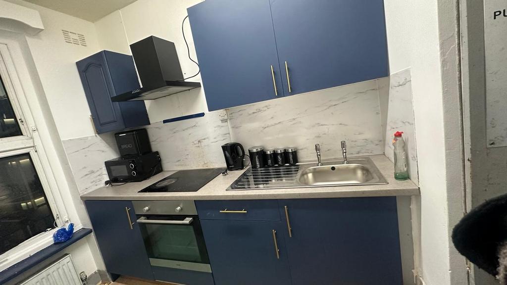 Modern compact kitchen with navy cabinetry, int...