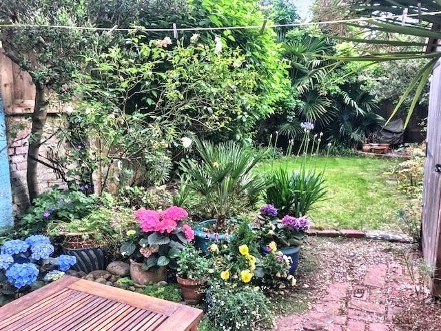 Well-kept private garden with a paved patio, pl...