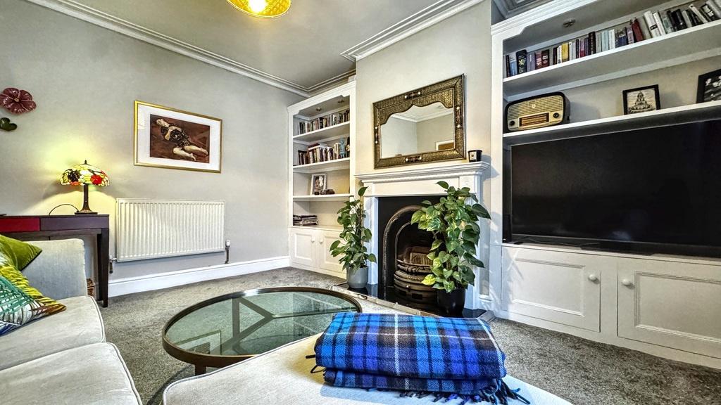 Bright, stylish living room with built-in shelv...