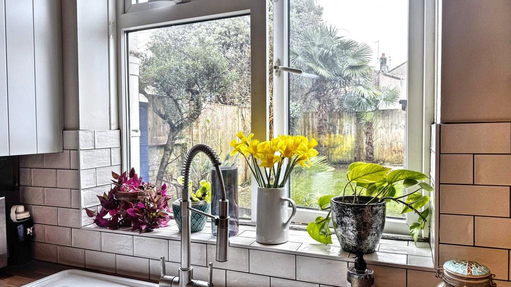 Bright kitchen sink area with a large window ov...