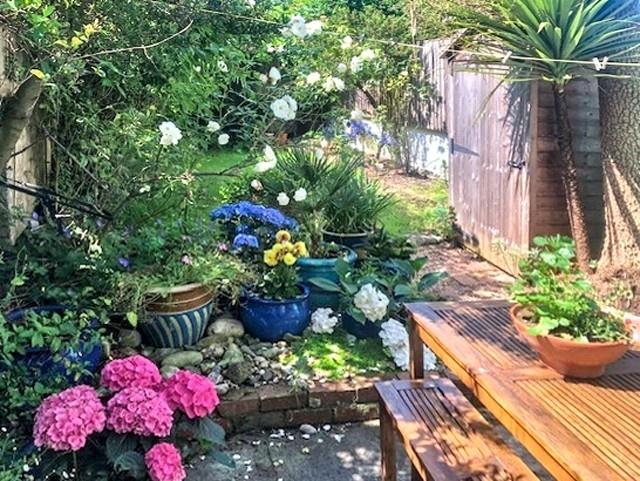 Charming, well-kept garden patio with colourful...