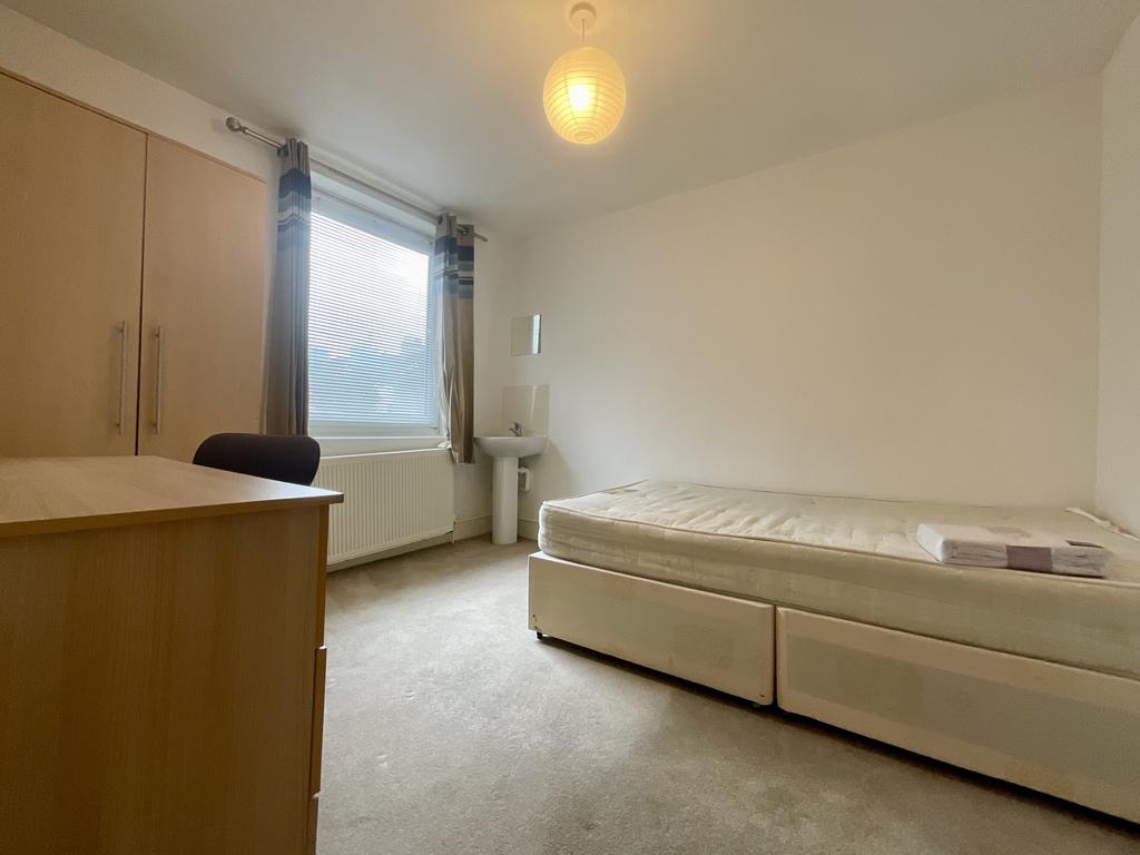 Neat, simply furnished bedroom with a single be...