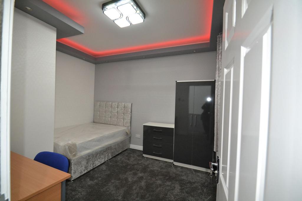 Neat, modern single bedroom with a plush uphols...