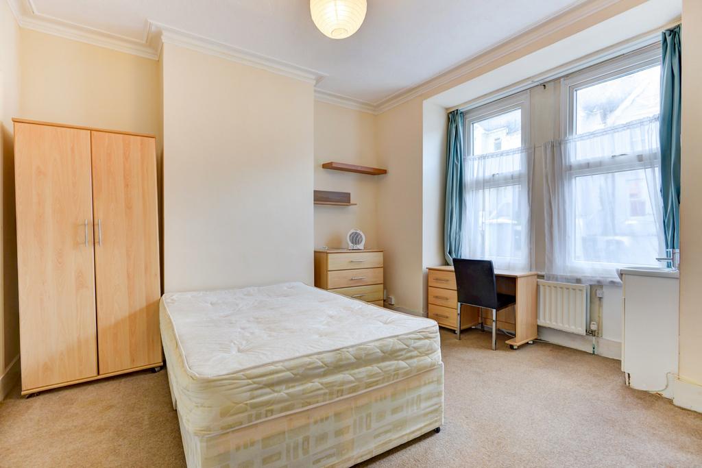 A tidy and well-lit bedroom featuring a comfort...