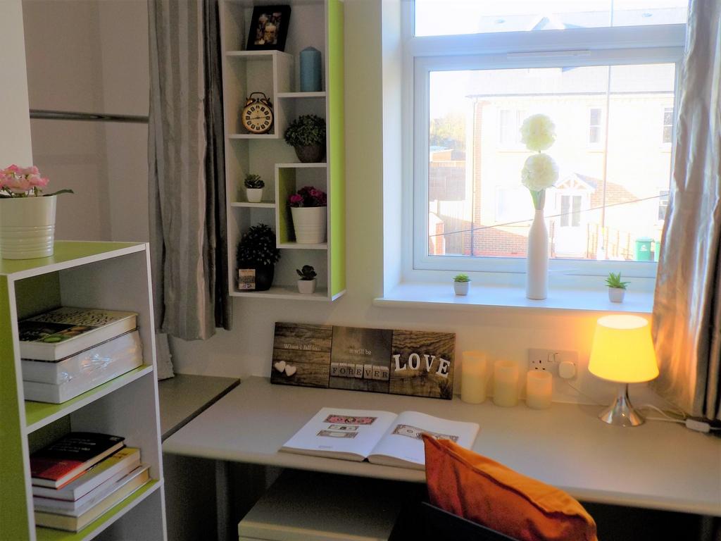 Bright, neatly arranged bedroom study area with...