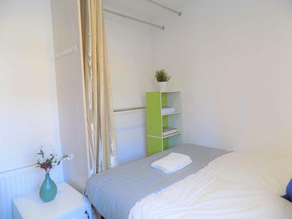 Bright, neat bedroom with a made double bed, so...