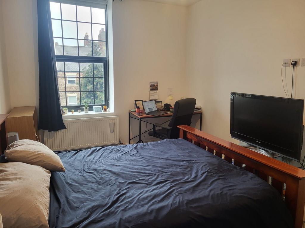 Bright double bedroom with a large window, comf...