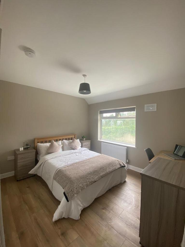 A clean and well-lit double bedroom featuring a...