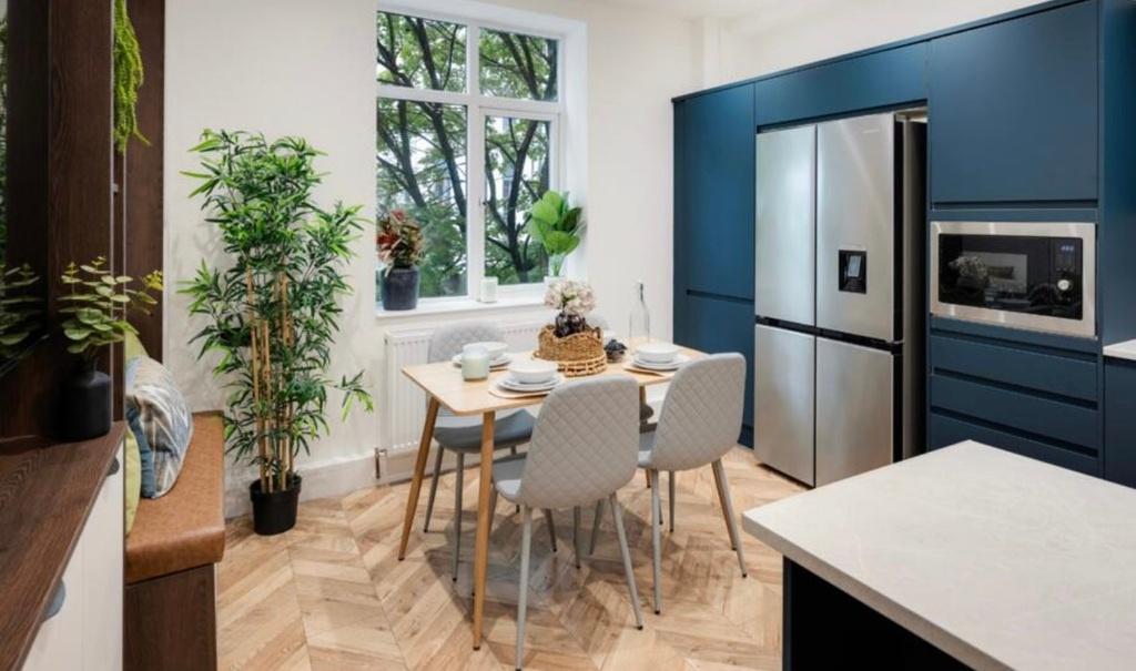Modern kitchen-diner with deep blue fitted unit...