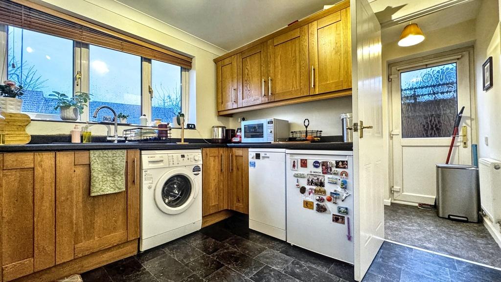 Bright, well-kept kitchen with wooden cabinetry...