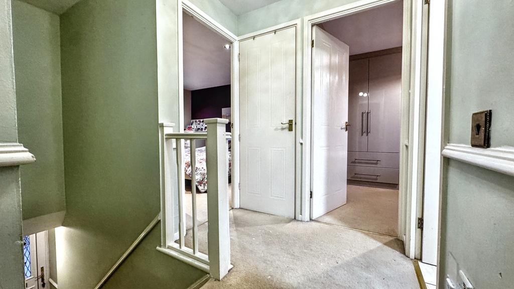 Bright, carpeted upstairs hallway with neutral ...