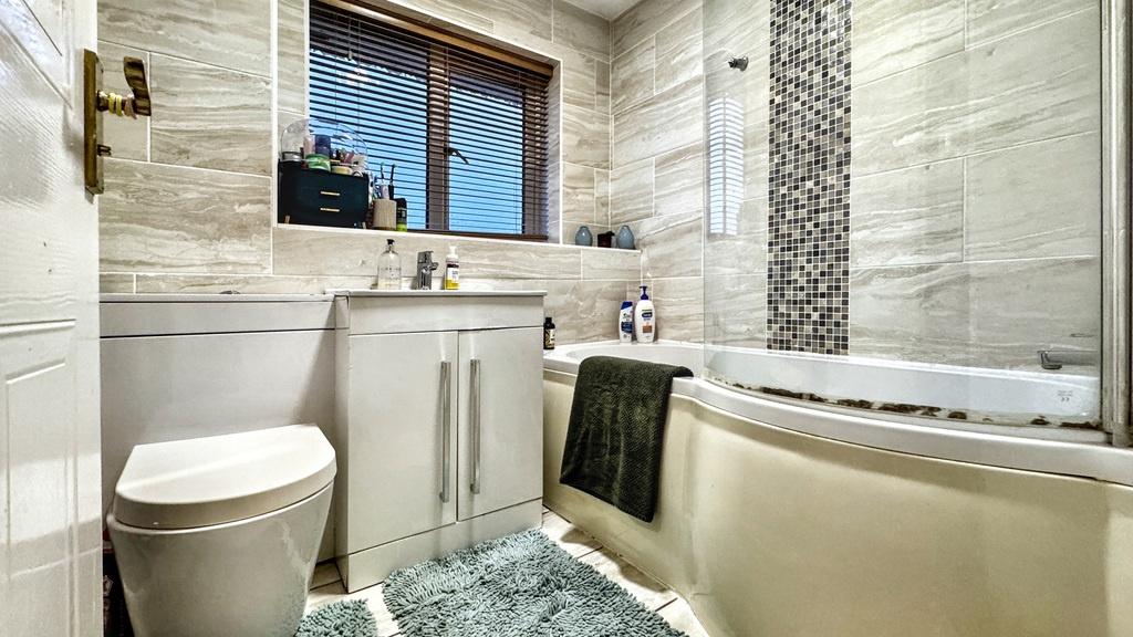Bright, modern bathroom with a curved bathtub, ...