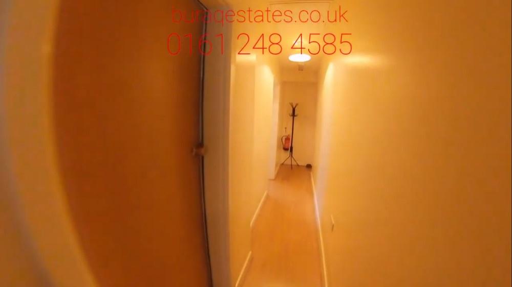 Narrow, well-lit internal hallway with warm pai...
