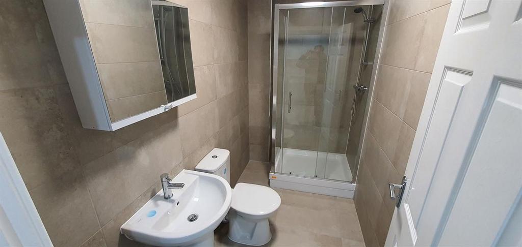 Modern tiled bathroom with a white sink, toilet...