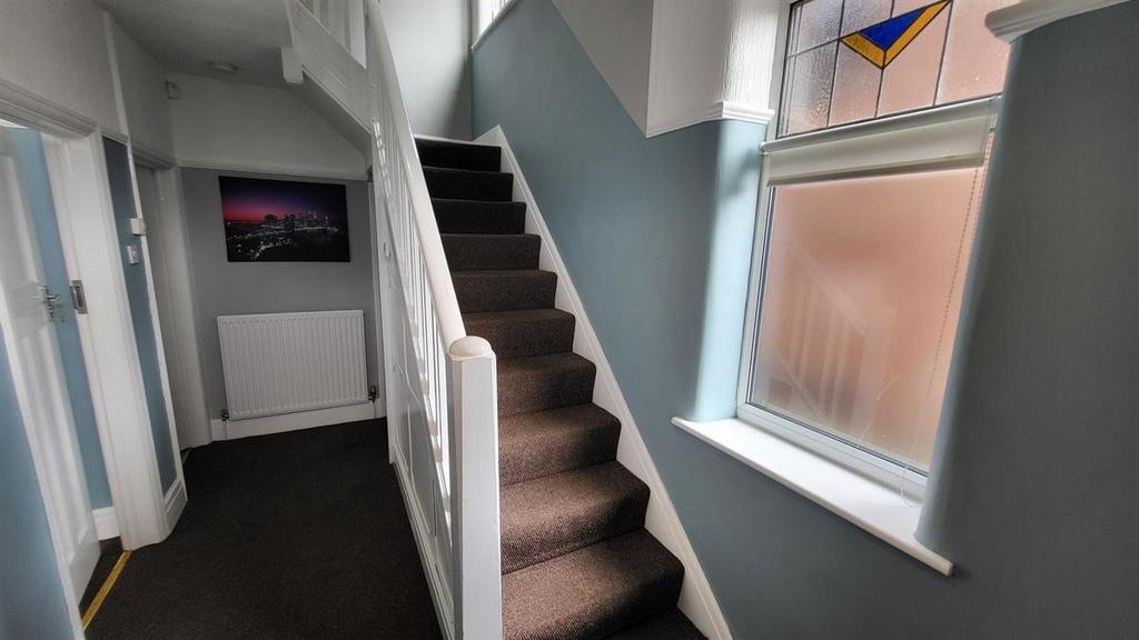 Bright, well-kept entrance hallway with a carpe...