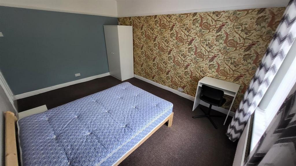 Bright double bedroom with patterned feature wa...