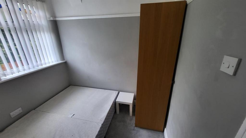 Simple single bedroom with a large window provi...