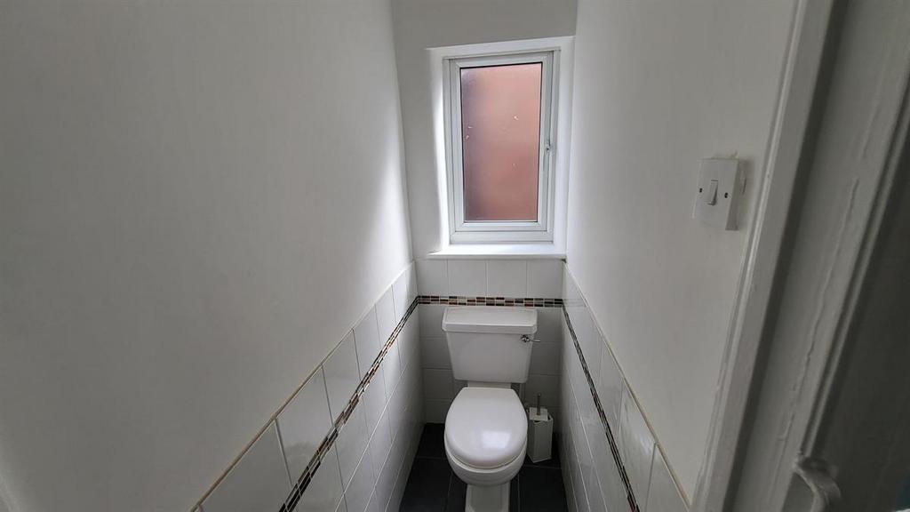 Compact, freshly painted WC with a modern white...