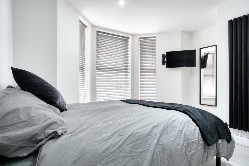 A modern and inviting bedroom featuring a large...
