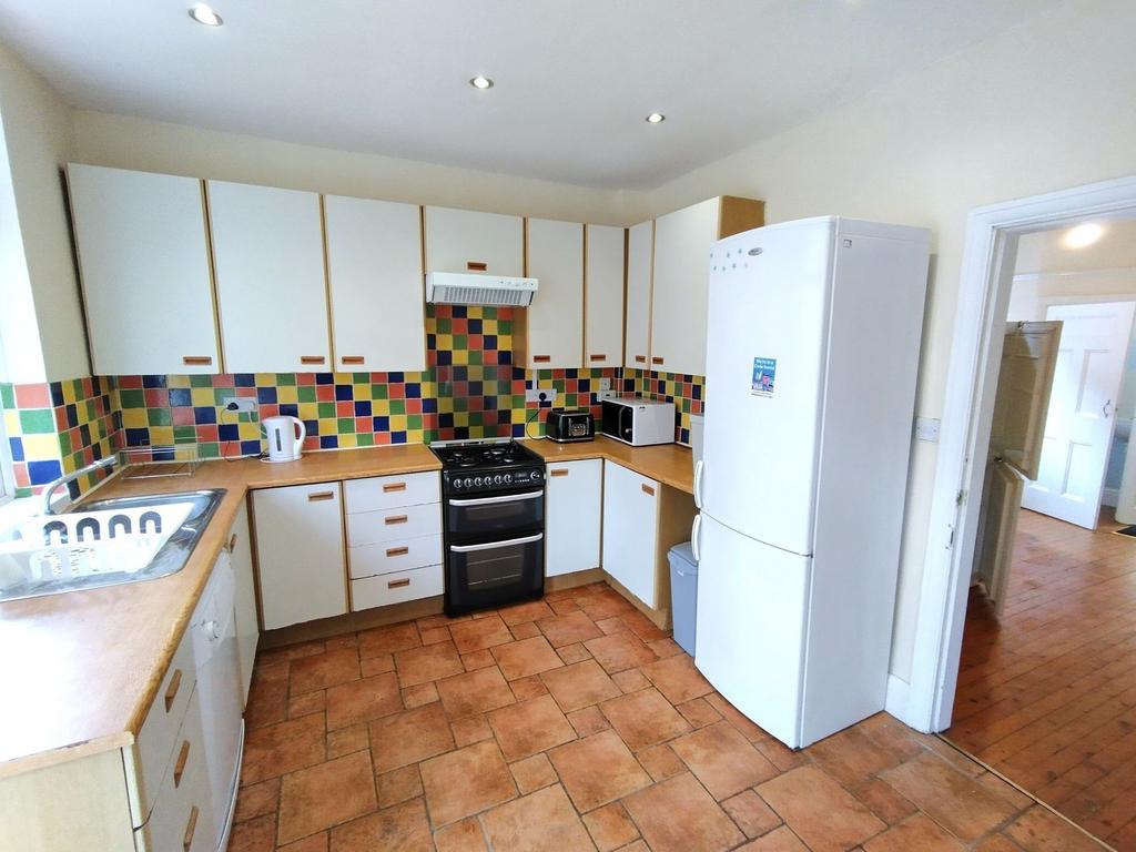 Bright, well-equipped kitchen with colorful til...