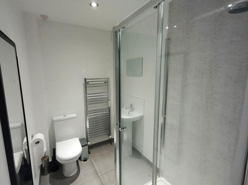 Contemporary bathroom with a glass-enclosed sho...