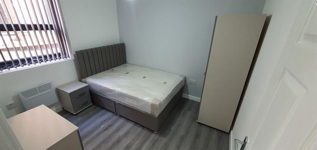 Bright, simply furnished double bedroom with a ...