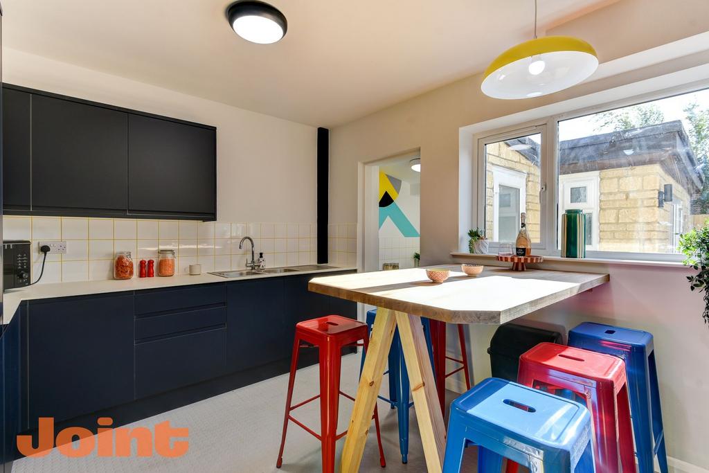 A modern kitchen featuring sleek dark cabinetry...