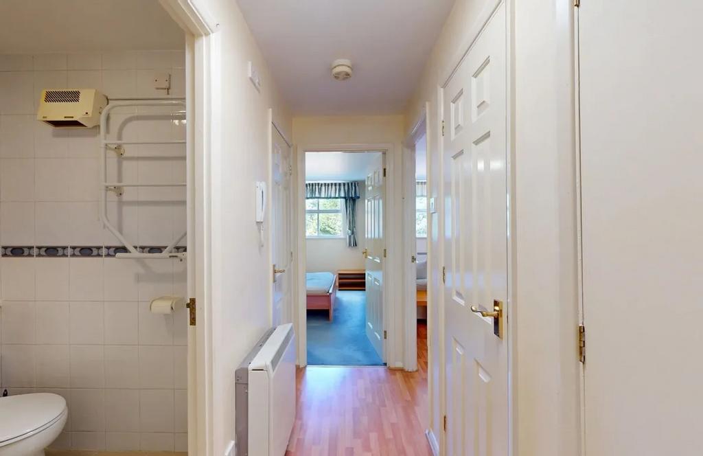 Bright, well-kept hallway with light wood floor...